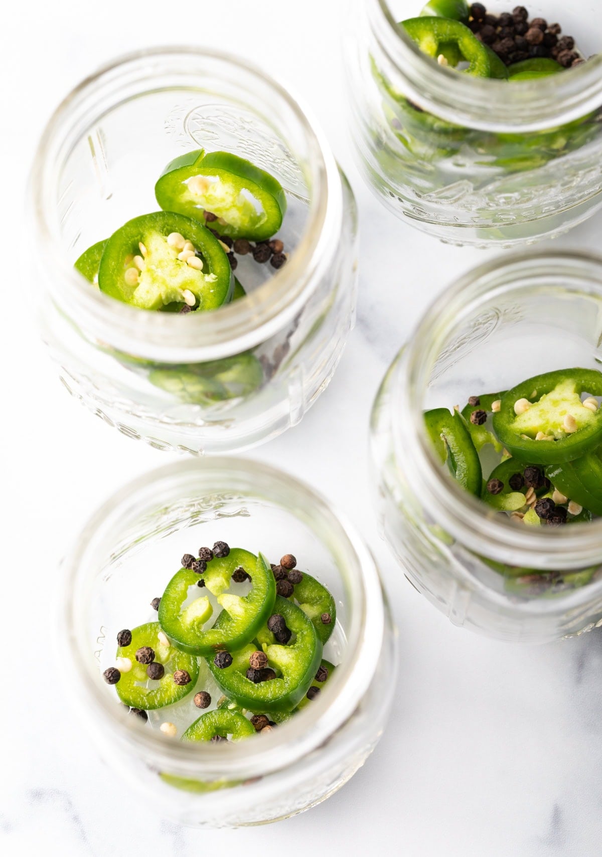 jalapeno slices and peppercorns in jars