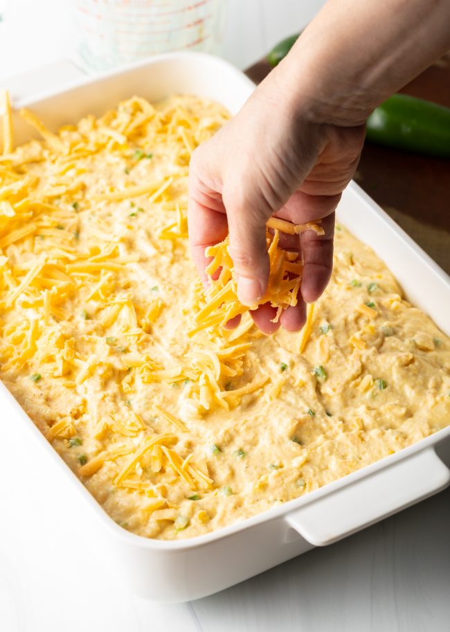 adding shredded cheese to the top of the unbaked batter
