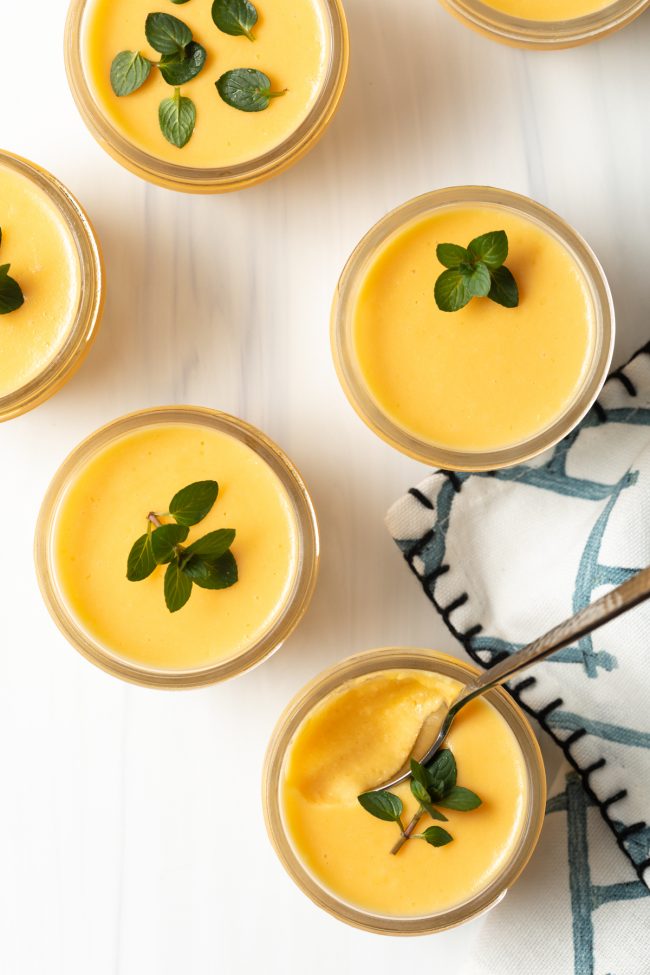 overhead view of 4 dairy free Chinese mango pudding dessert pudding cups with mint leaves
