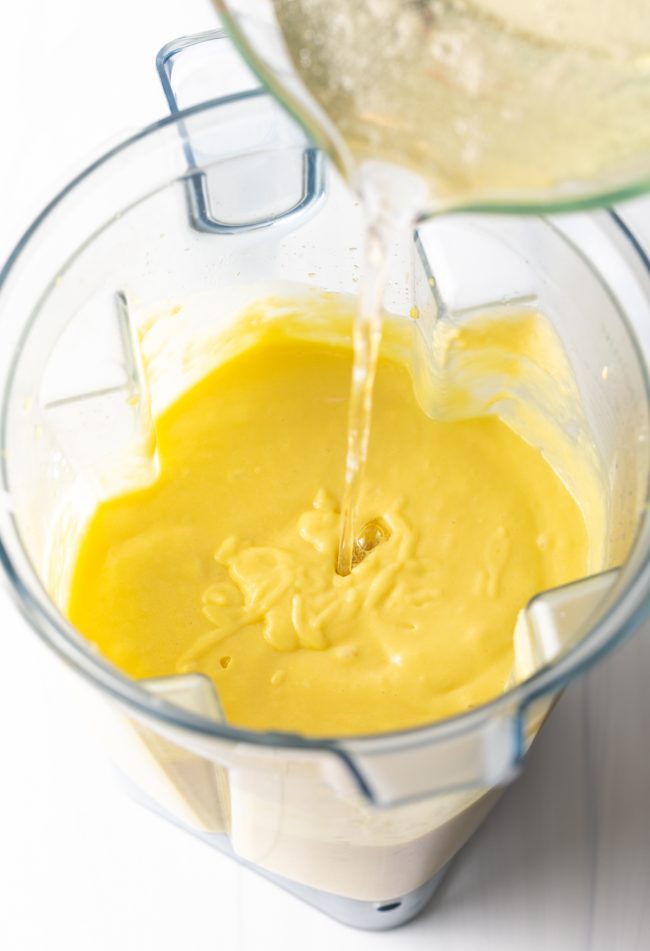adding the gelatin and sugar mixture to the pureed mango and coconut in a blender