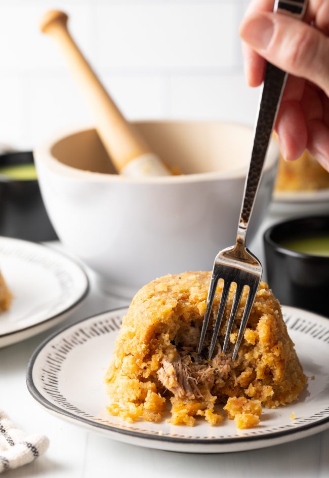 taking a bite of mofongo stuffed with shredded beef