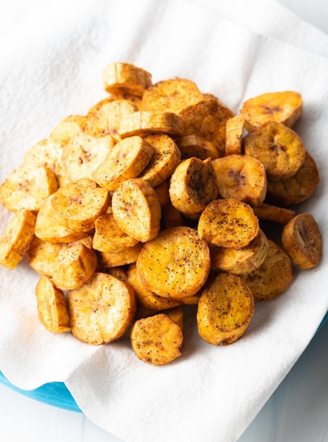 Fried plantains draining on a paper towel. 