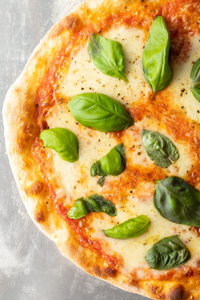 overhead view of freshly baked neapolitan pizza with basil