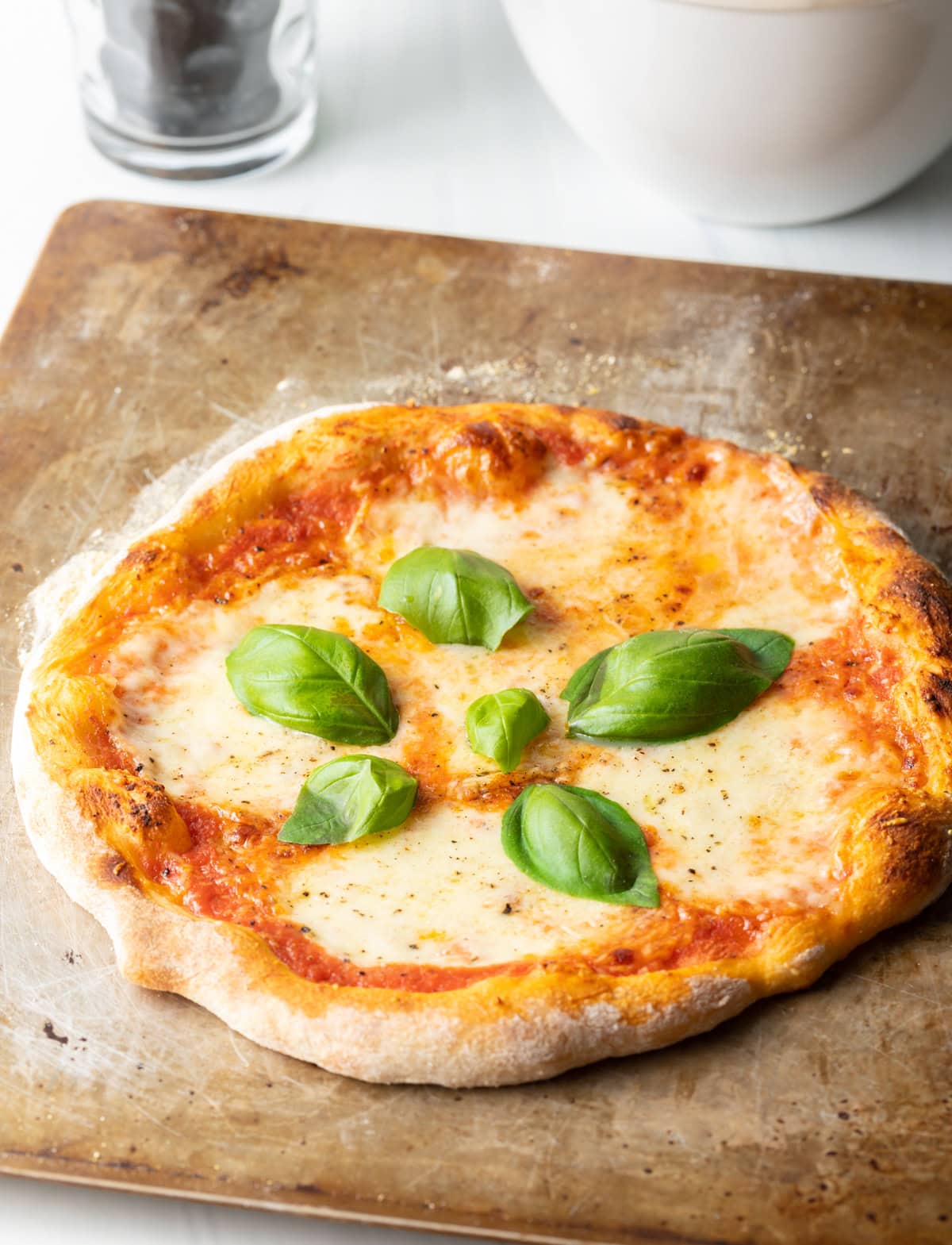 Baked Neapolitan pizza with fresh basil leaves.