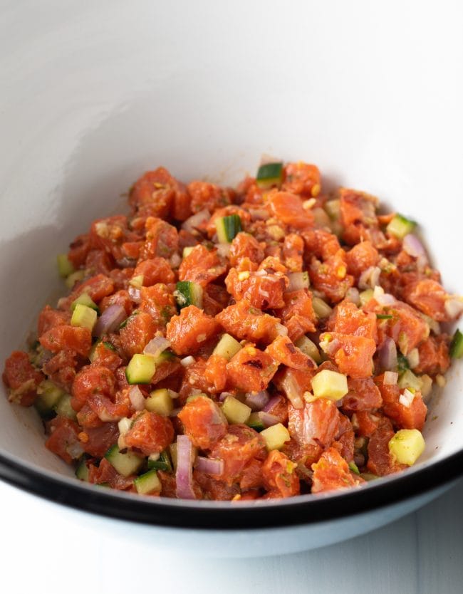 Veggies and salmon mixed together in a bowl. 