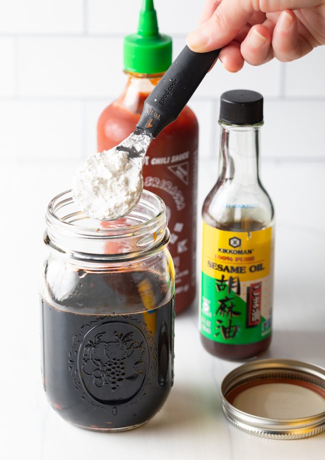 adding cornstarch to the mason jar with soy sauce