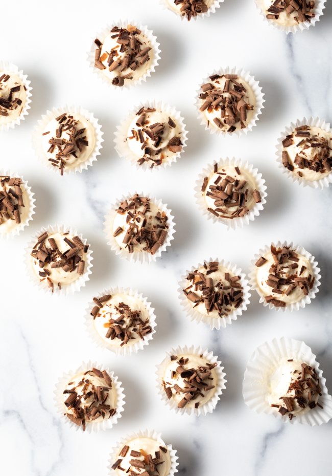 top view a dozen no bake keto bites in paper cups topped with chocolate shavings