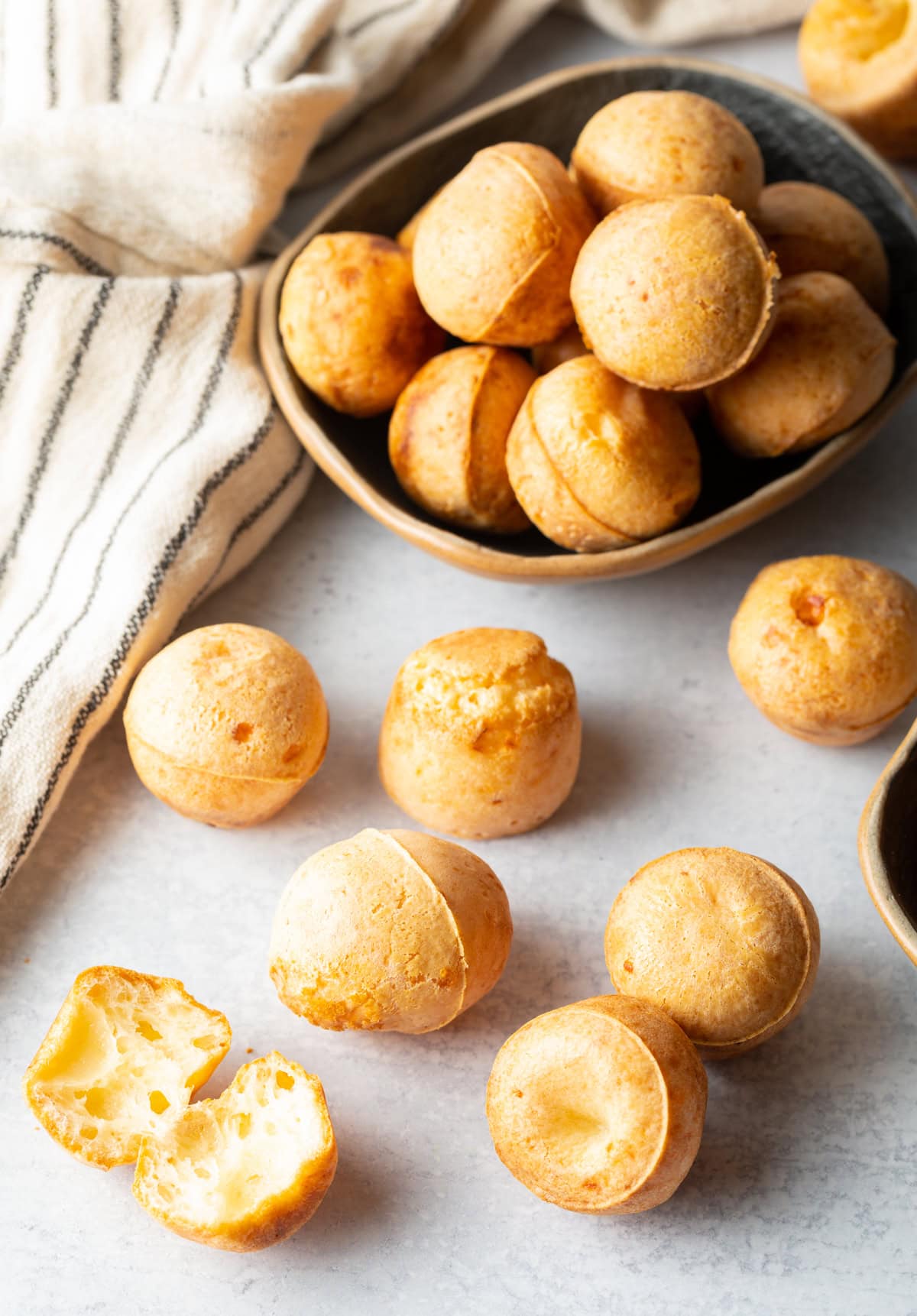 overhead view of Brazilian Cheese Bread puffs on a baking sheet and in a bowl