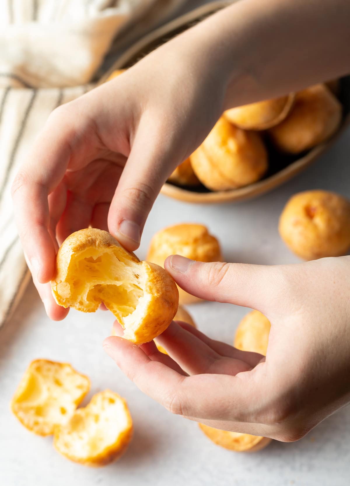 hands pulling apart a cheesy baked puff
