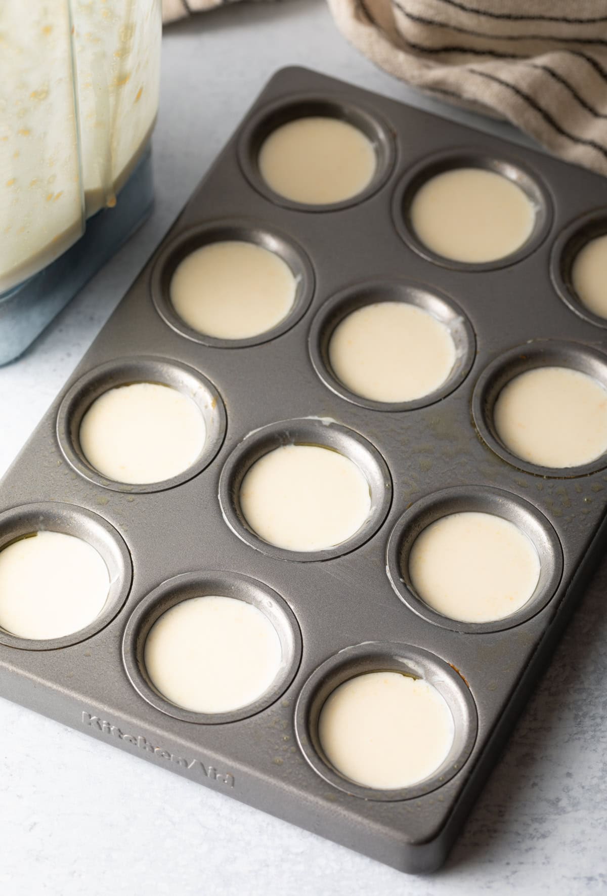 mini muffin tins filled with pao de queijo batter