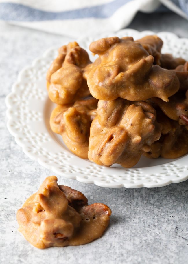 top view pecan pralines on a white plate, one candy on the table