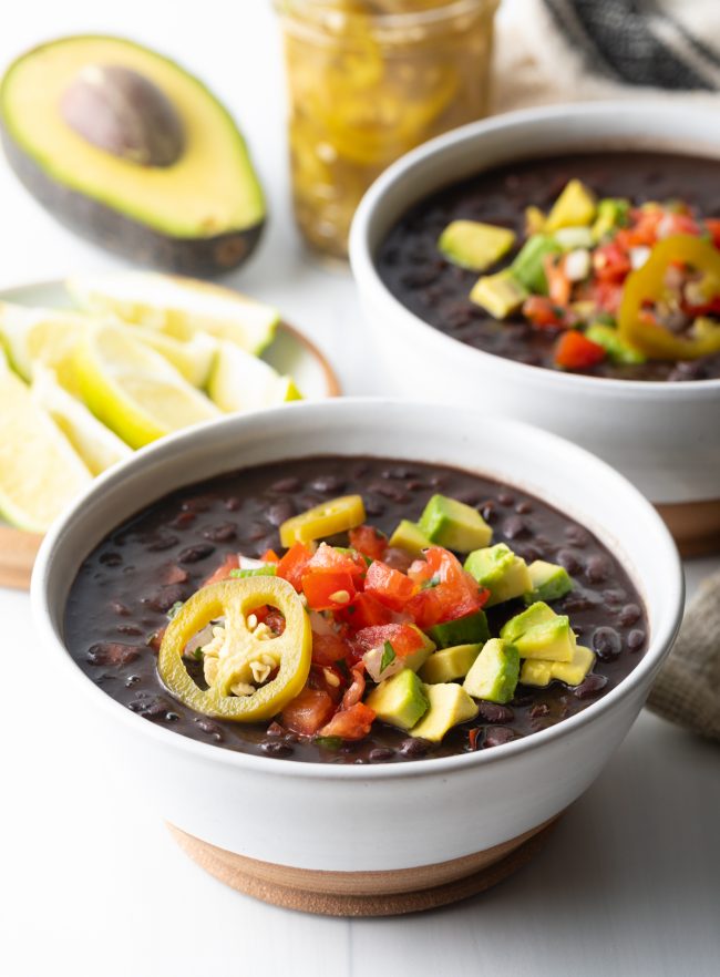 close up view of black bean soup topping with pico avocado and jalapeno slices