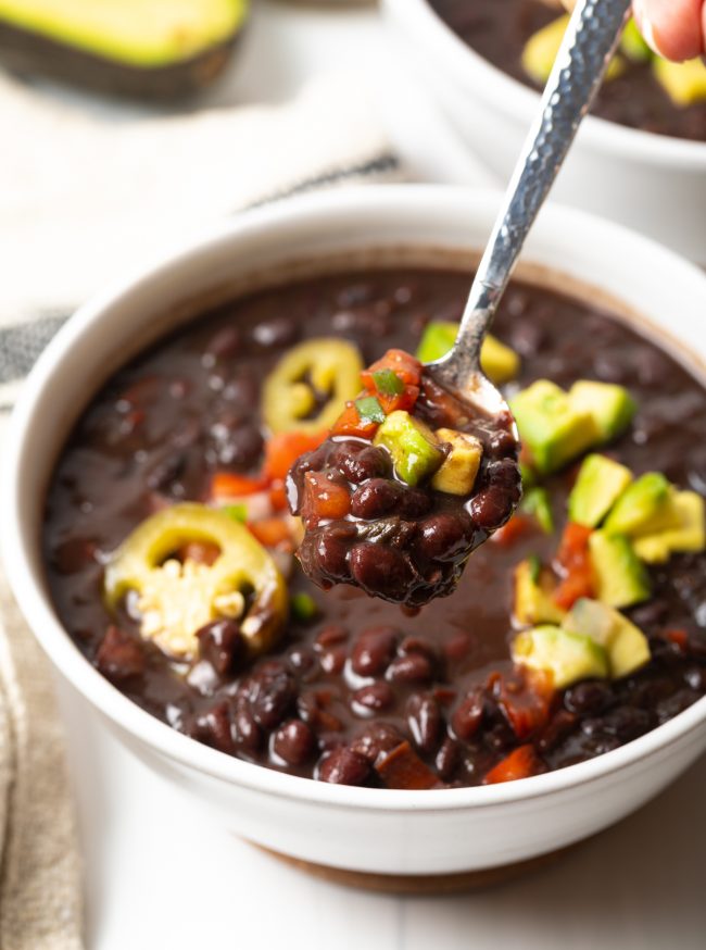 bowl of vegan black bean soup with spoonful towards camera