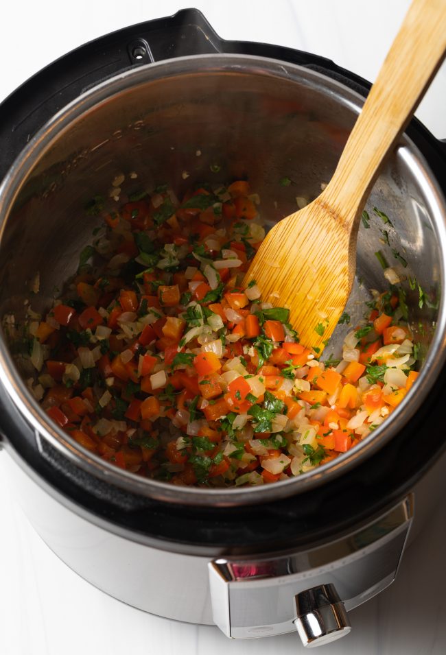 sautéing aromatics in an instant pot with wooden spatula