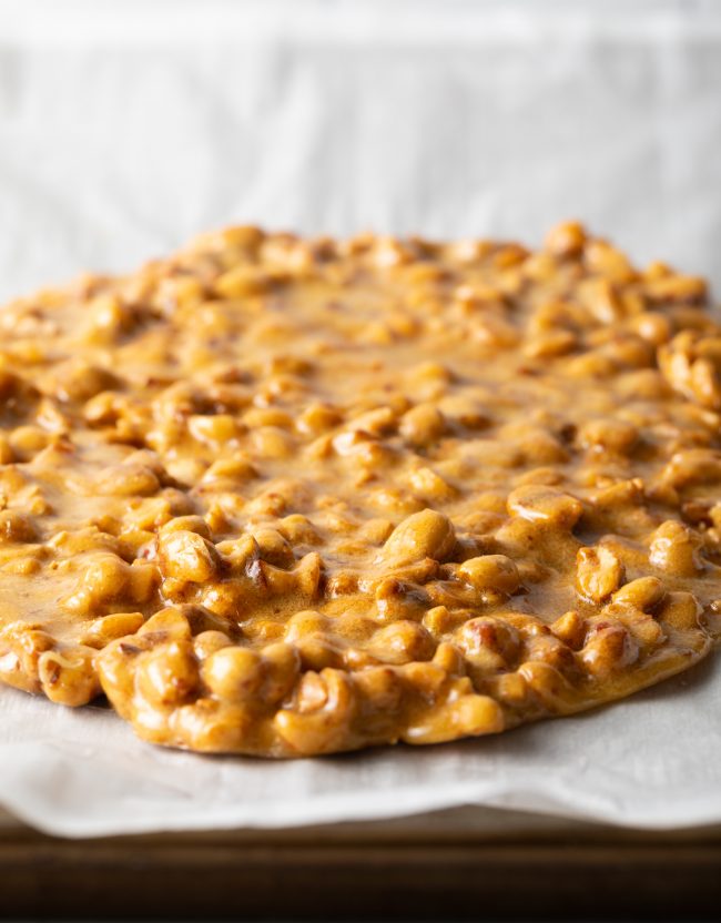 spreading the microwave peanut brittle on parchment
