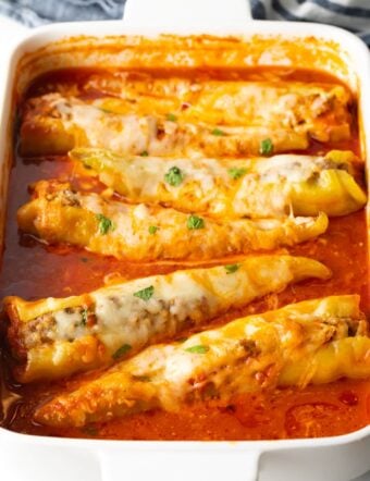 sausage stuffed banana peppers with marinara sauce in pan