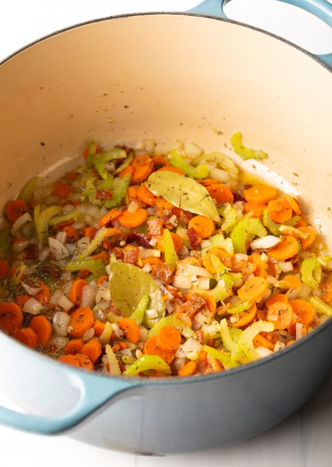trinity of celery, carrots, onions cooking in a large pot