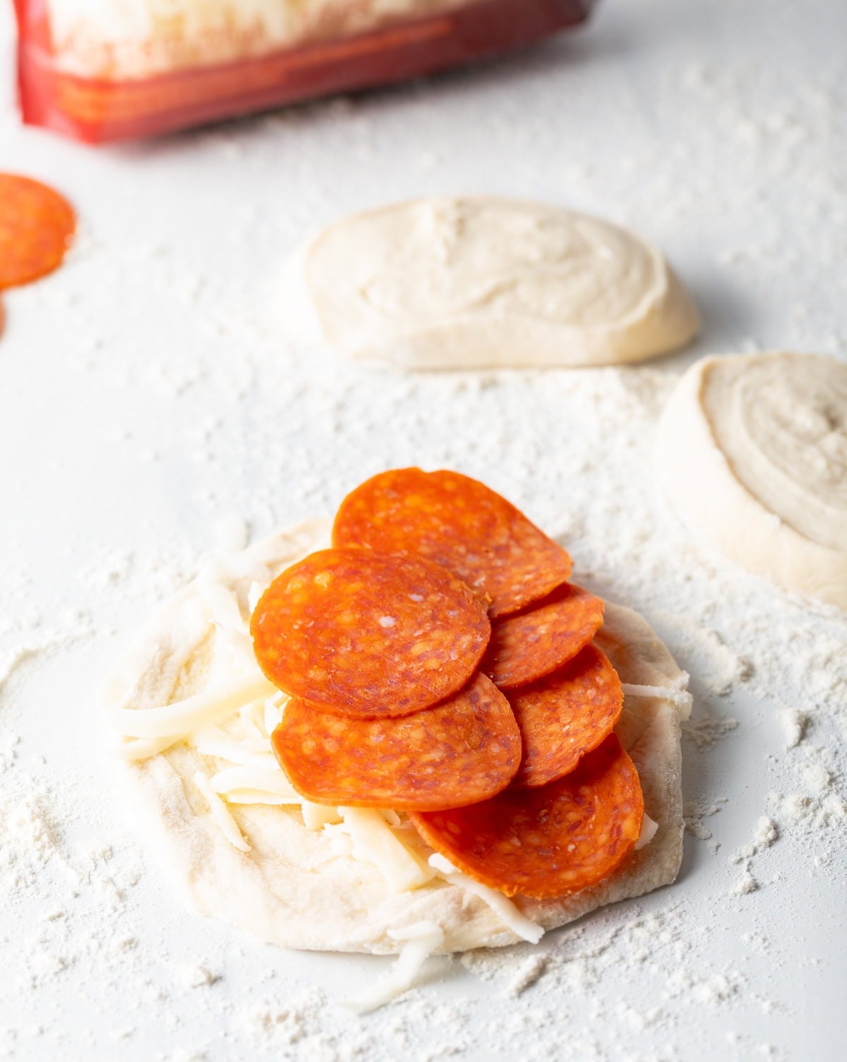Pepperoni on a piece of pizza dough..