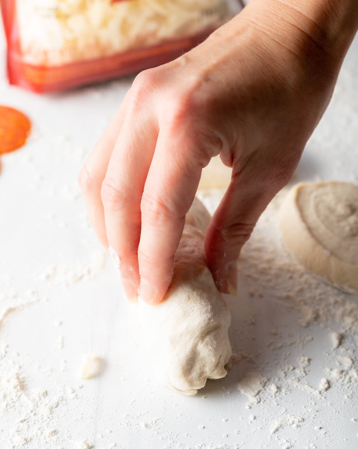 Hand rolling a pepperoni roll.