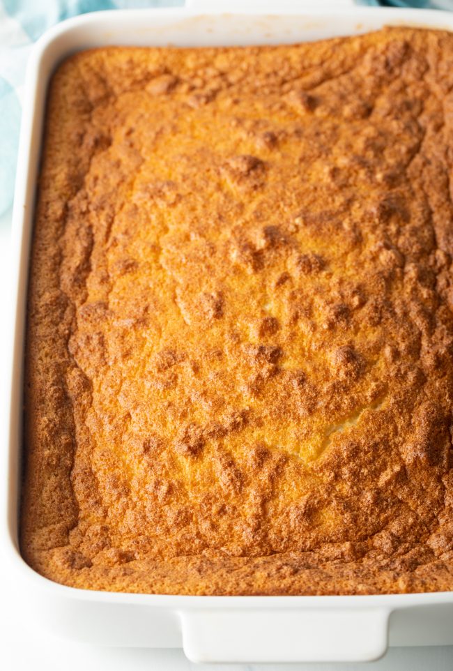 top view golden brown cake baked in a large white pan