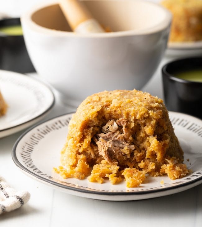 Mofongo on a plate stuffed with shredded meat. 