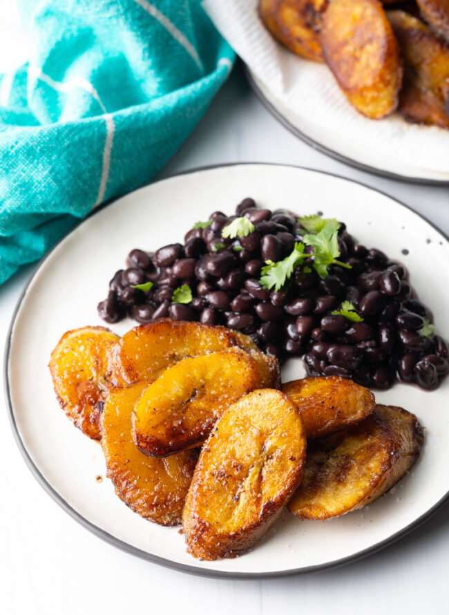 overhead finished plate with pan fried plantains and black beans with cilantro
