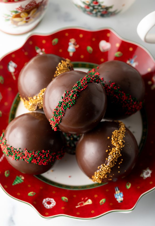 top view decorated cocoa bombs stacked on a christmas plate