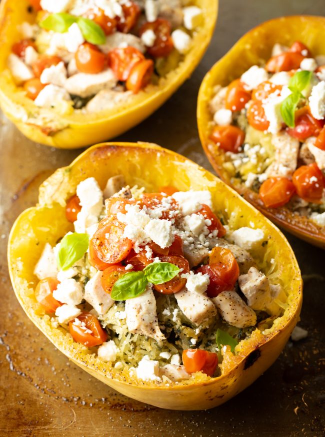 low carb spaghetti squash pasta with chicken, tomatoes, and basil pesto topped with feta