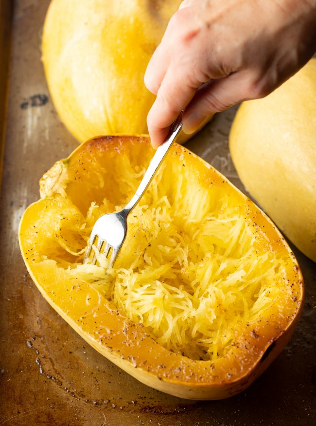 fork scraping strands from roasted spaghetti squash