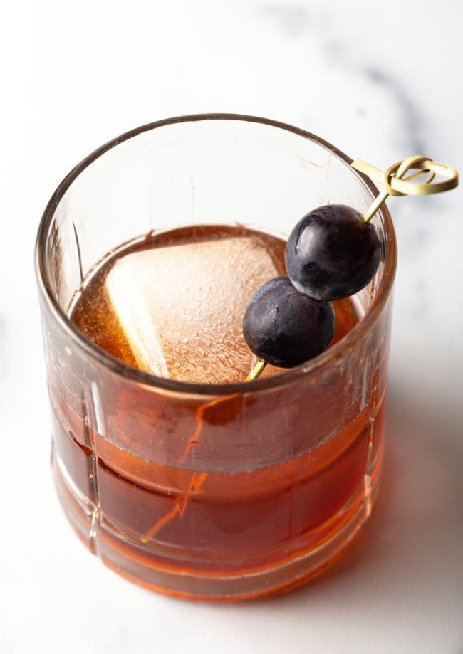 Top view peanut butter whiskey drink with ice and grapes.