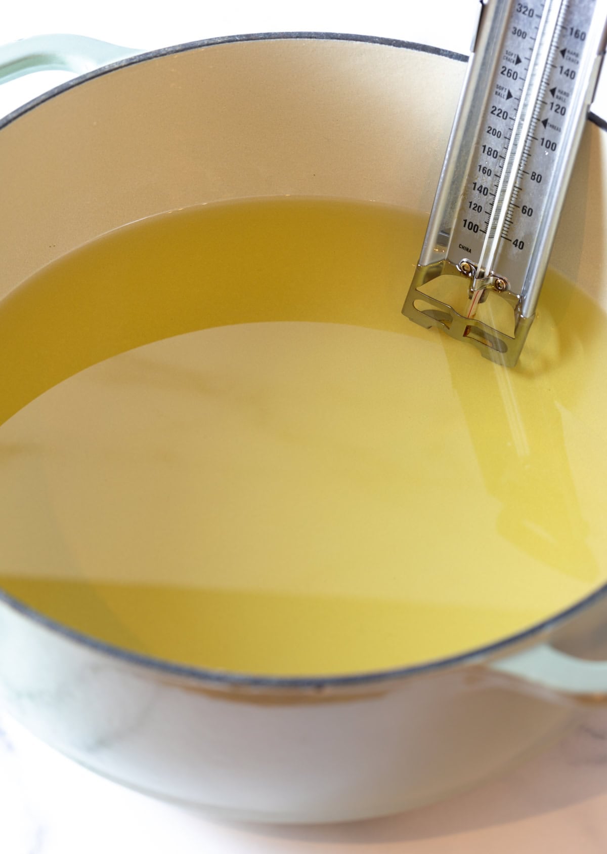 Large pot of oil with thermometer stuck on the side.