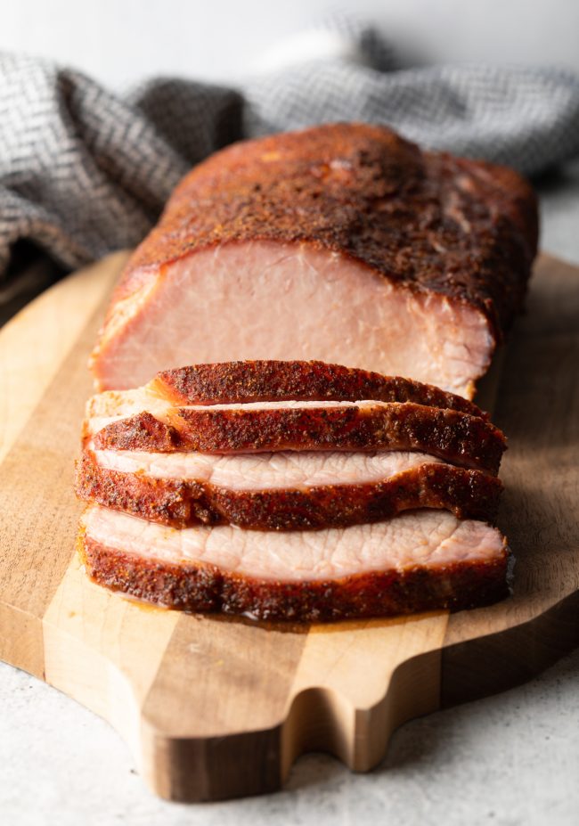 close view sliced smoked pork loin on a cutting board