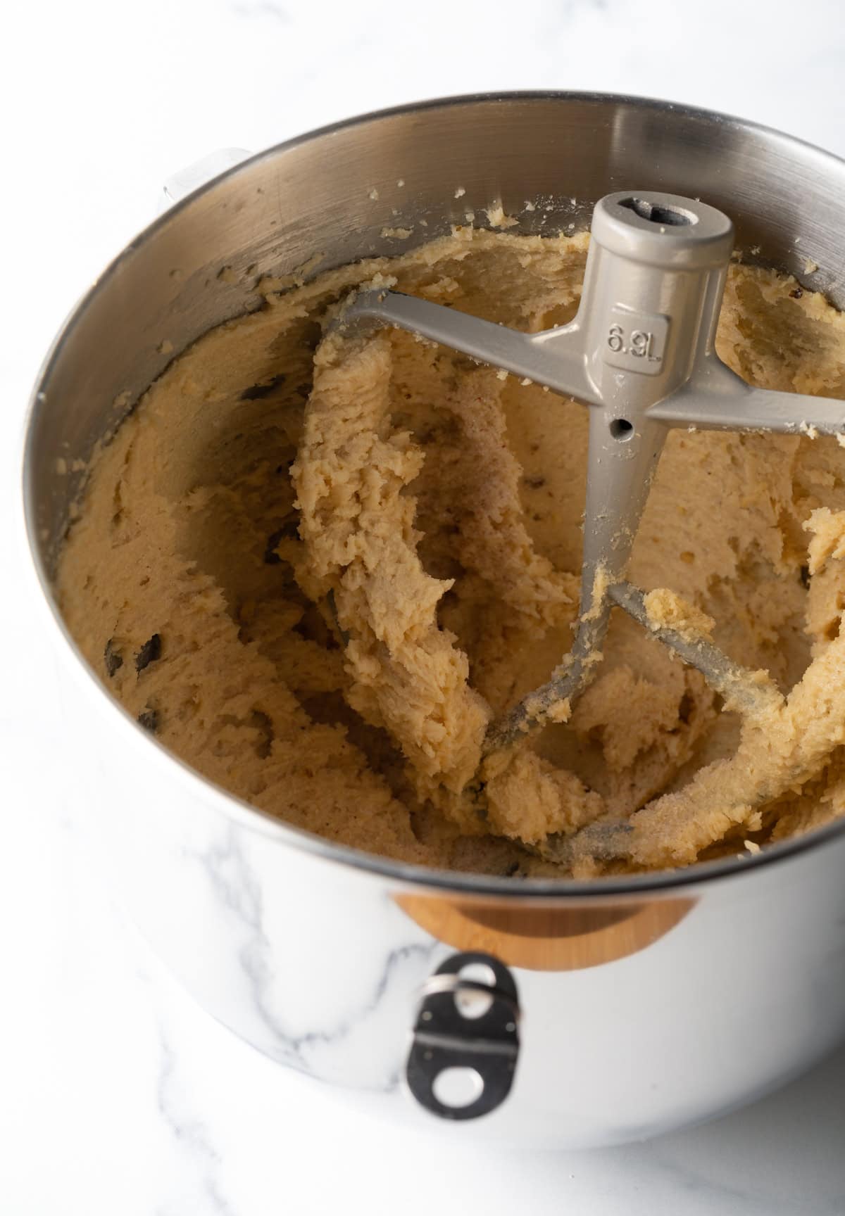 A stand mixer is mixing a butter and sugar mixture for walnut chocolate chip cookies.