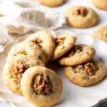 Chocolate chip walnut cookies lined up in a circle on a white plate.