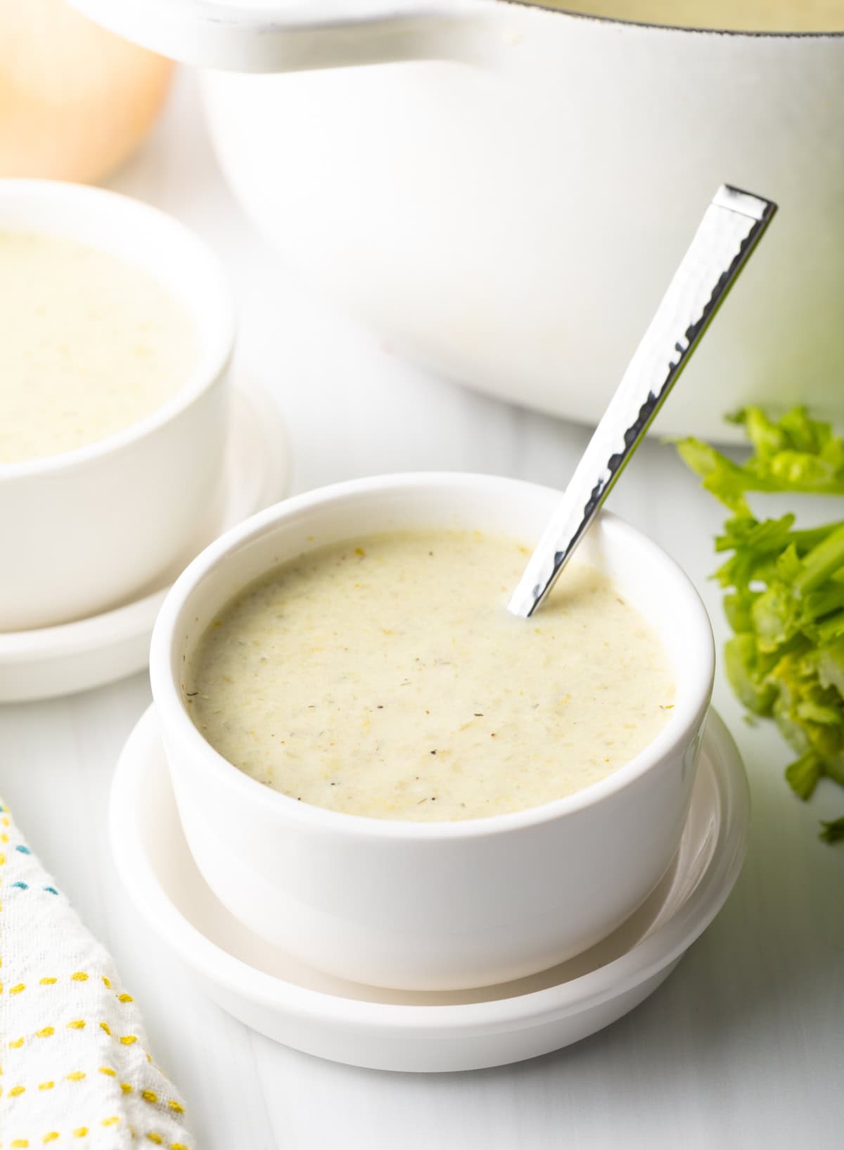 Bowl of celery soup with a metal spoon.