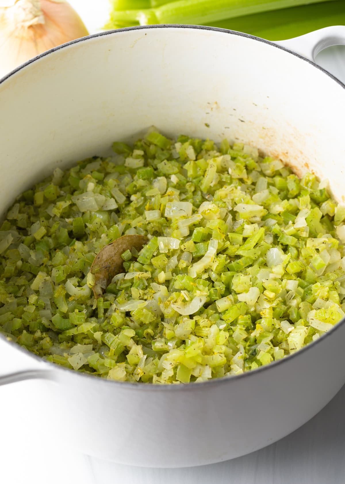 Chopped celery and onion cooking in a large pot.