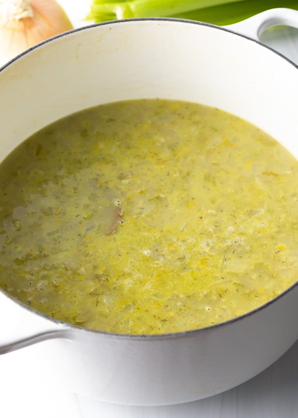 Broth added to chopped celery in a pot.