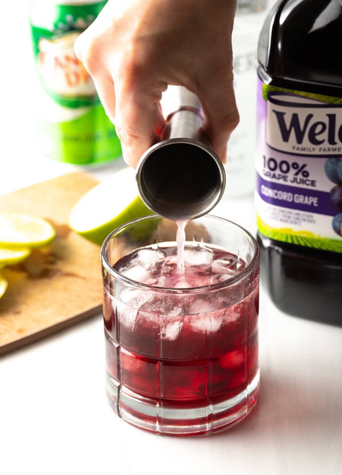 Hand adding shaker of lime juice.