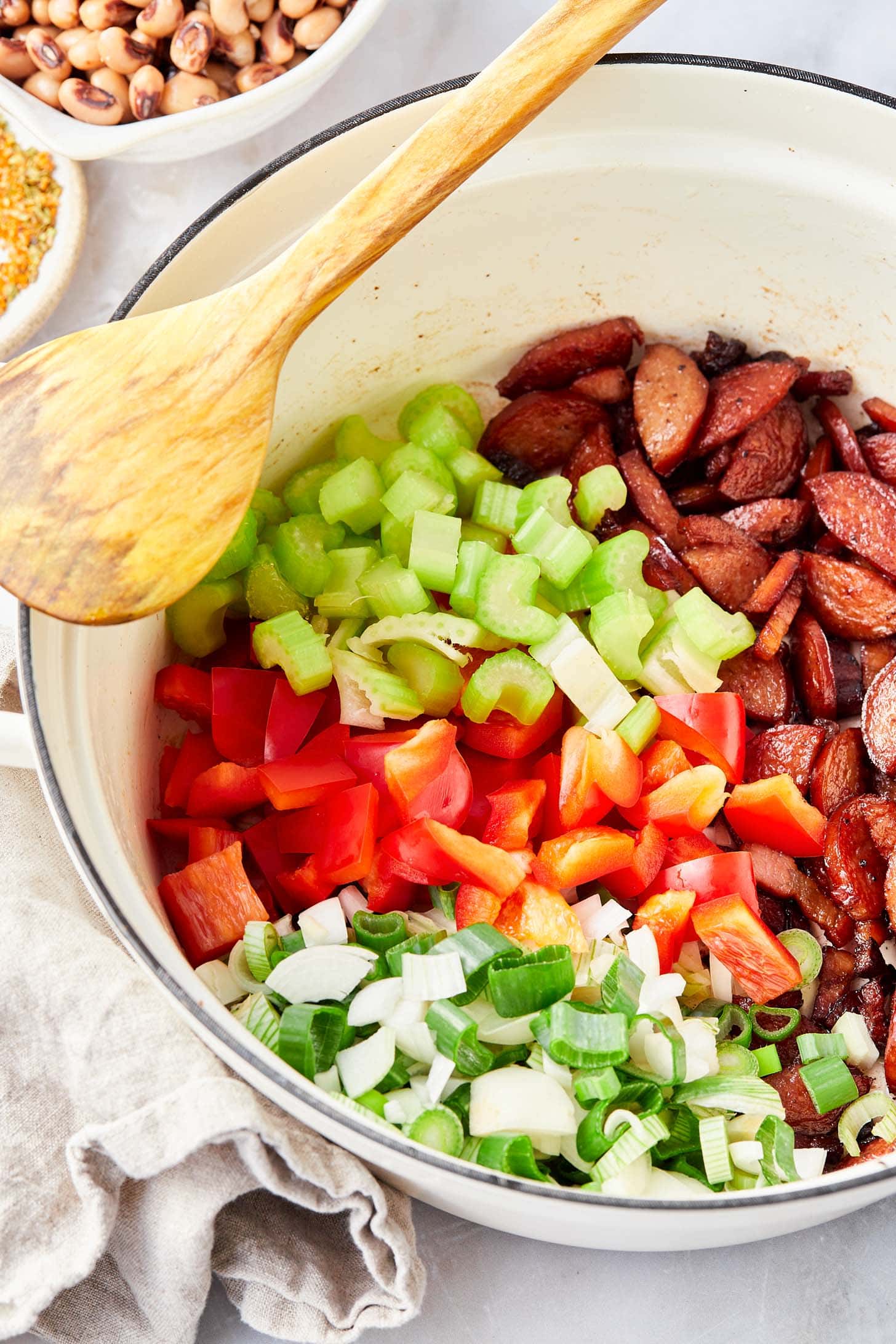 Vegetables being sauteéd in skillet with sausage.