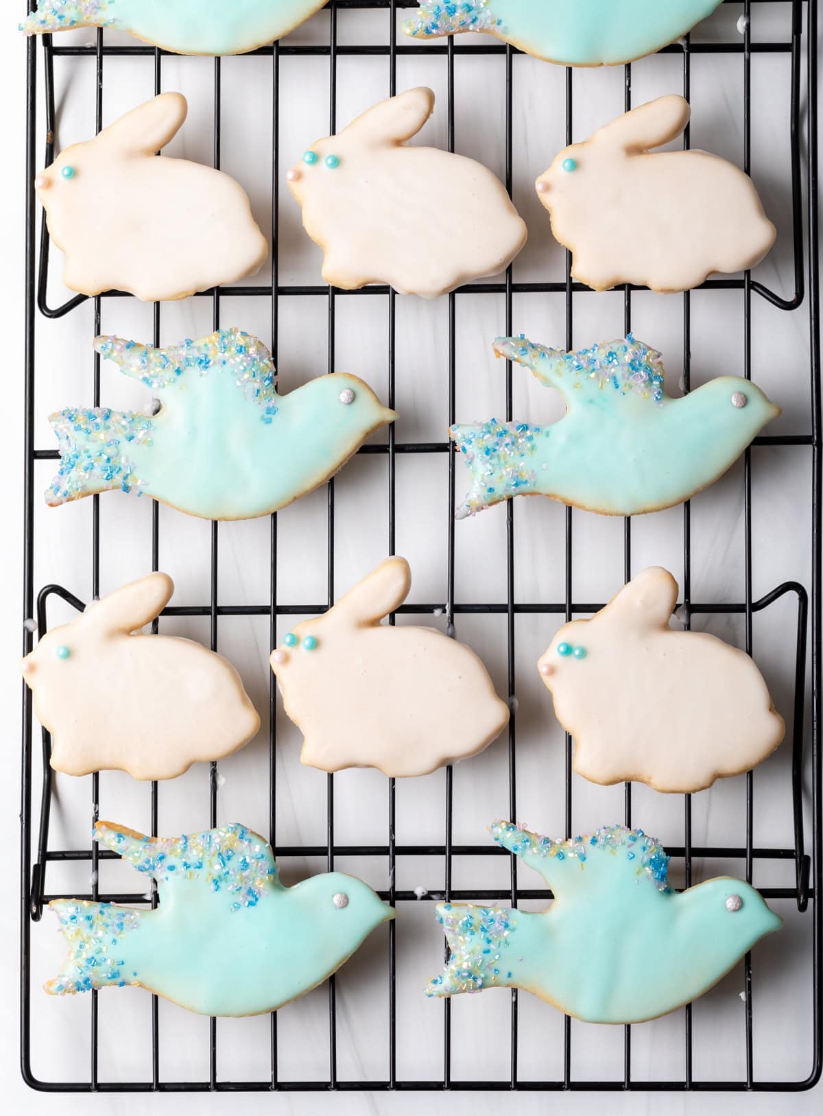 Decorated sugar cookies in the shape of bunnies and birds covered with icing. 