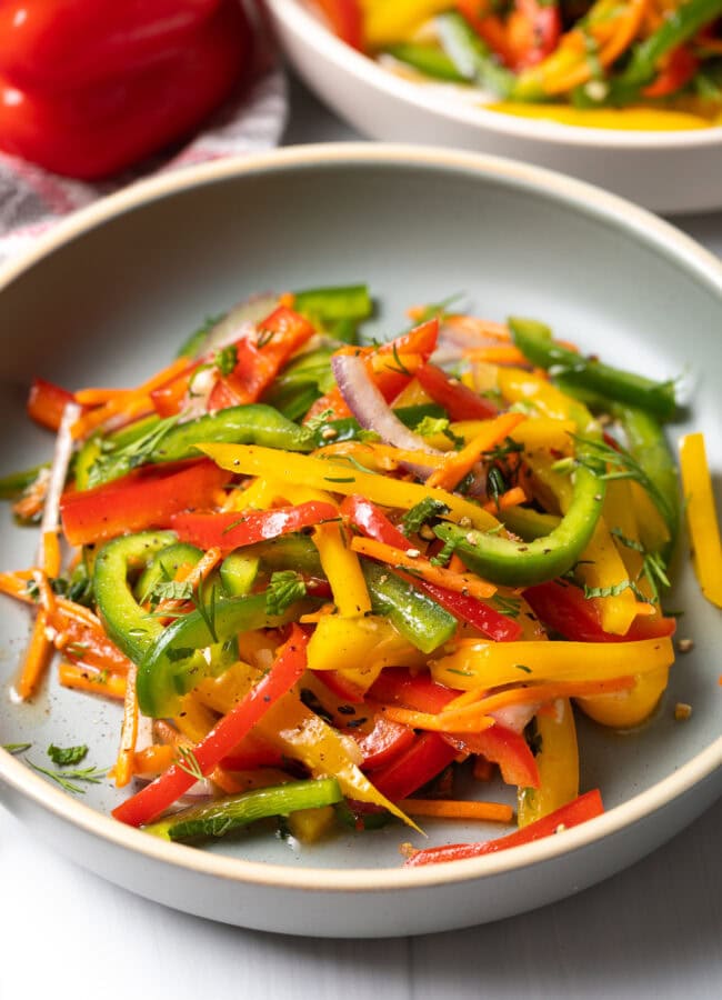 Yellow, green and red pepper summer salad in a plate.
