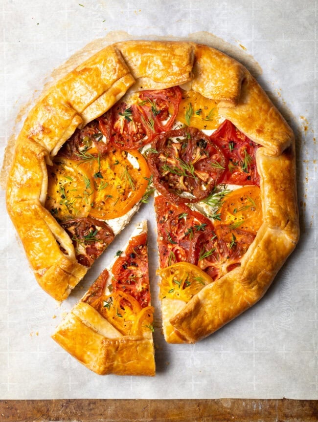 Top view baked savory crostata with slice pulled to the side.