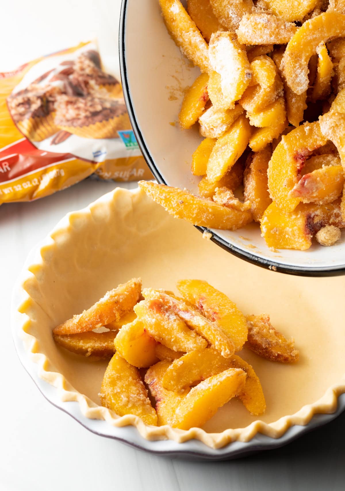 Pie pan being filled up with peach filling