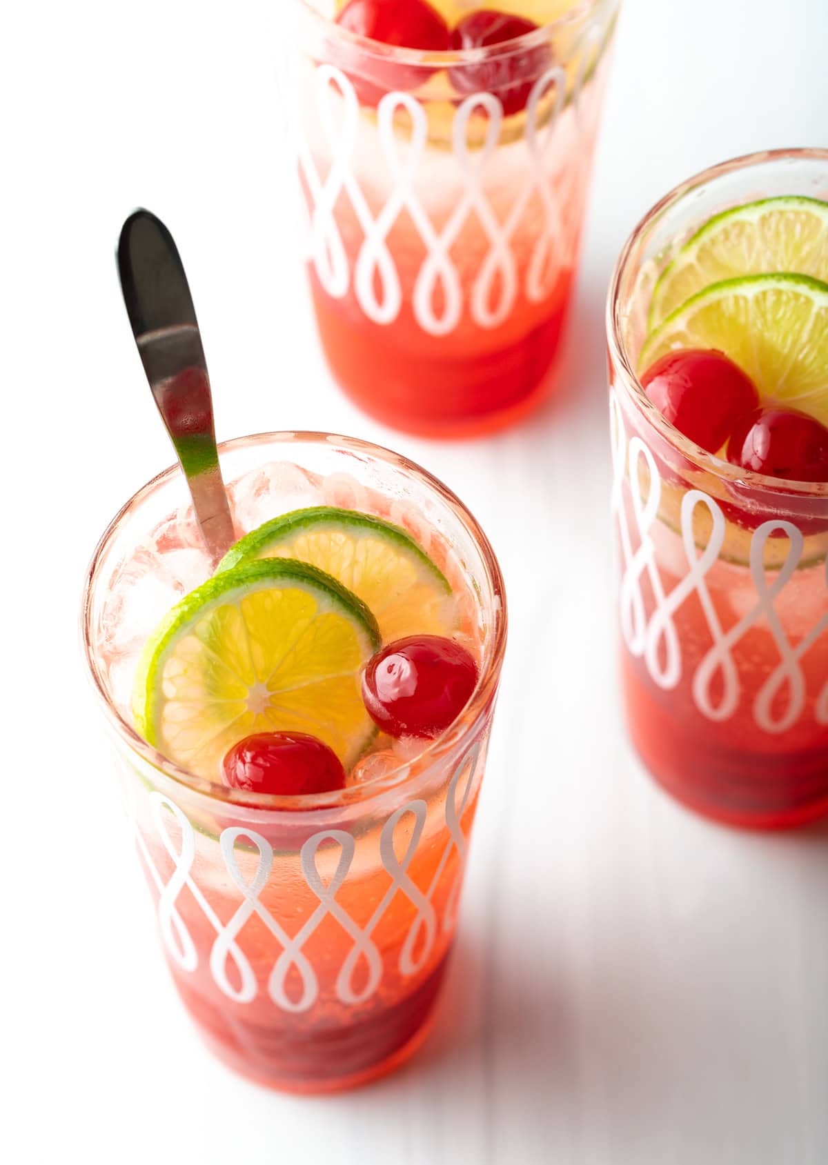 An overhead shot of three glasses of a 3-ingredient cherry limeade recipe.