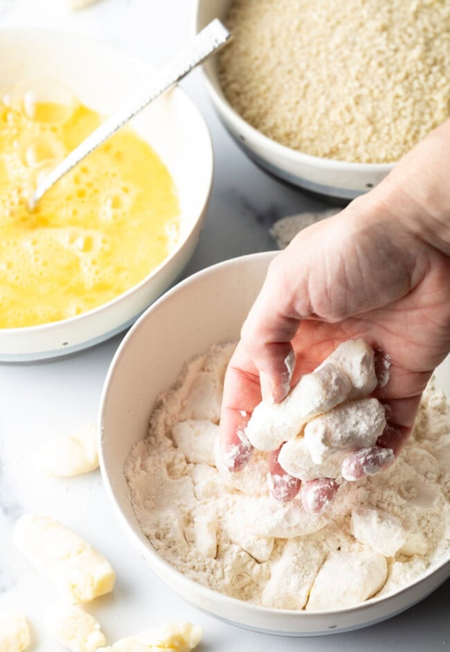Dredging cheese curds in egg and flour.
