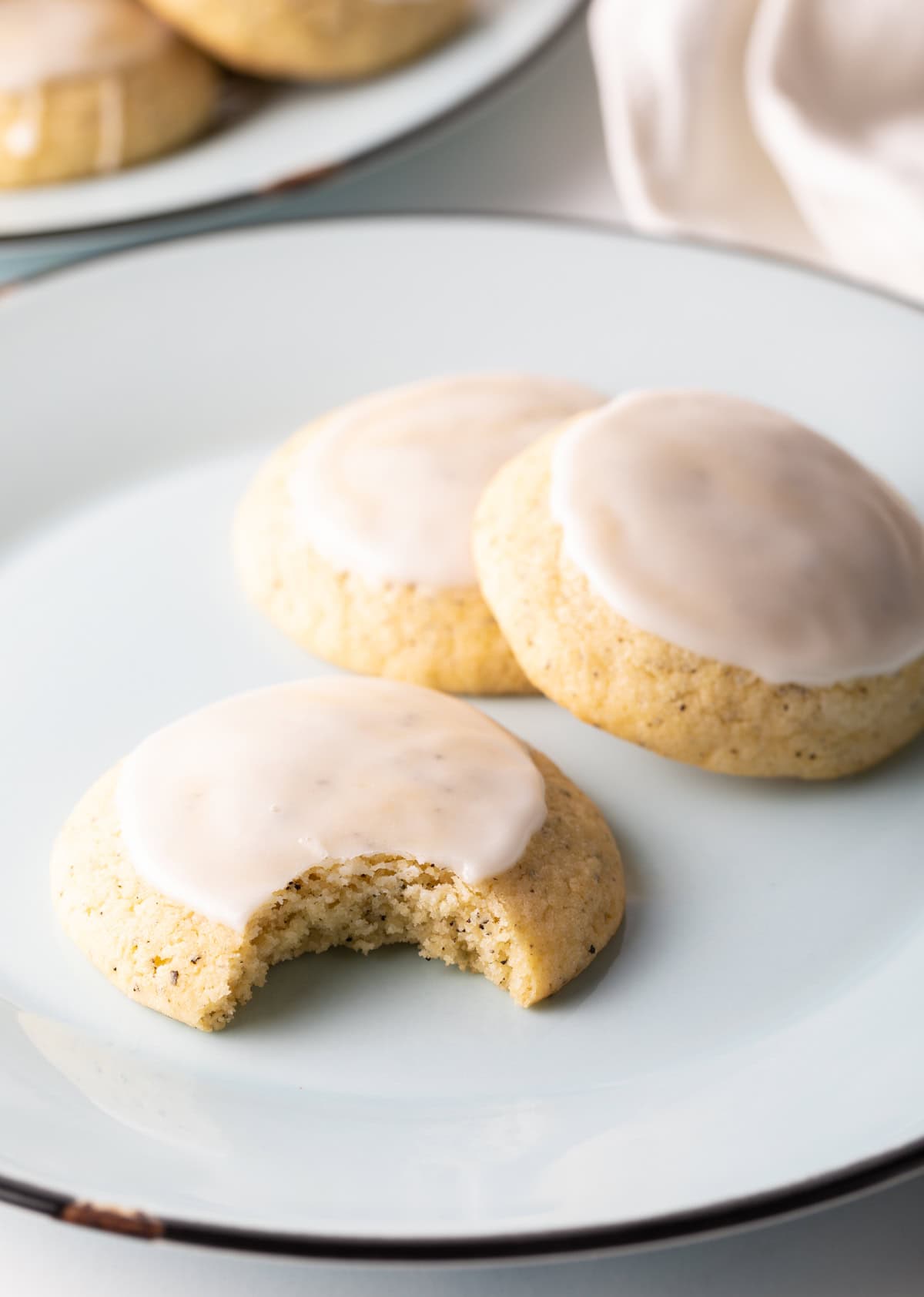 Plate of three cookies, the one closest to the camera has had a bite removed.