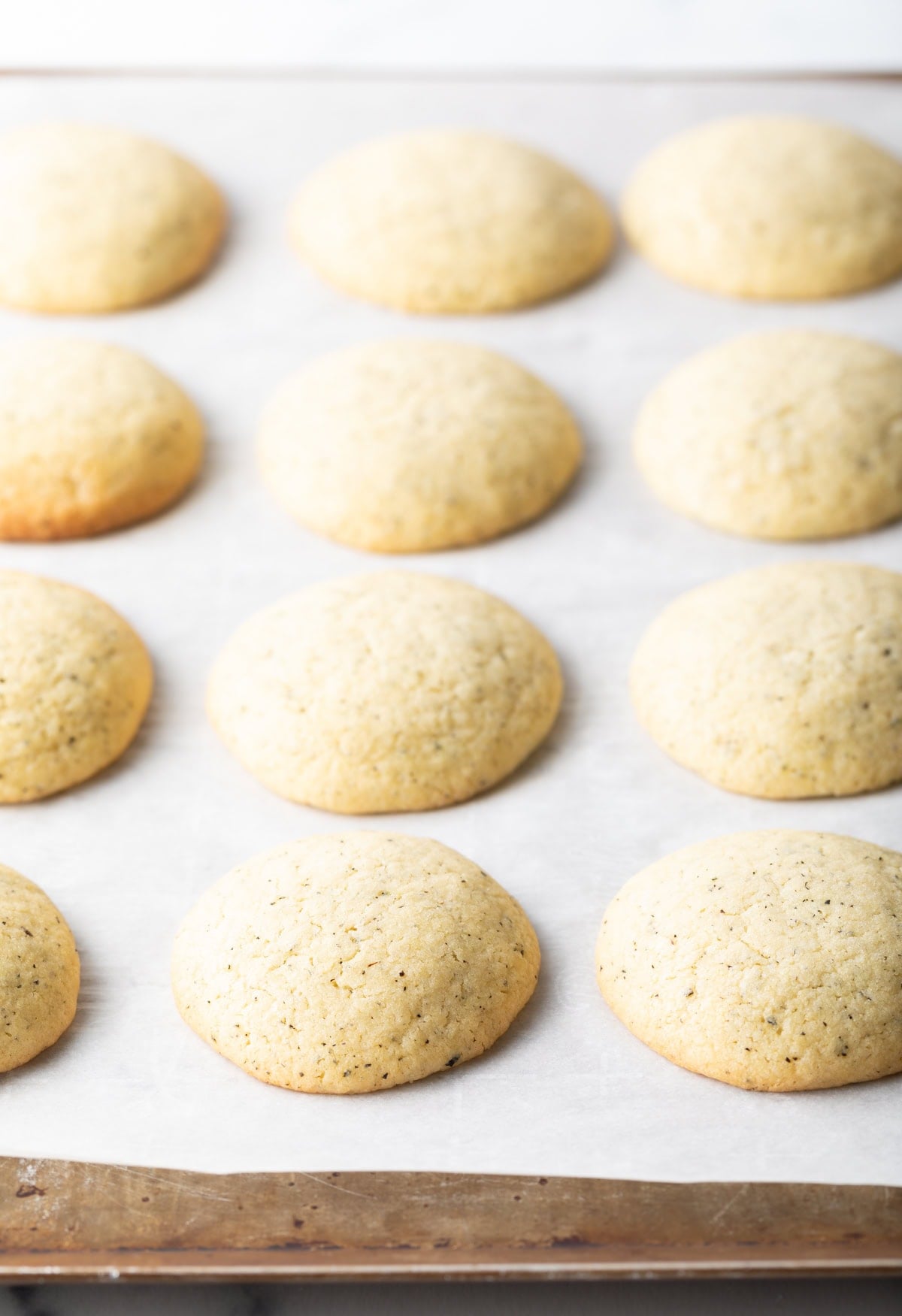 Baked soft tea cake cookies on a baking sheet.