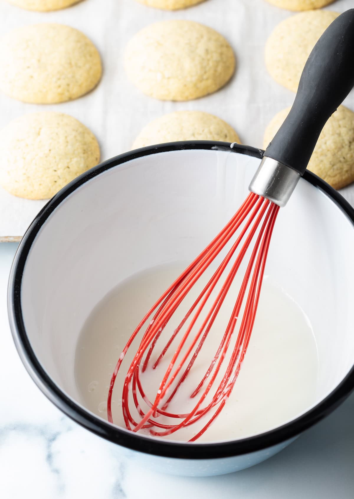 White mixing bowl with red whisk.
