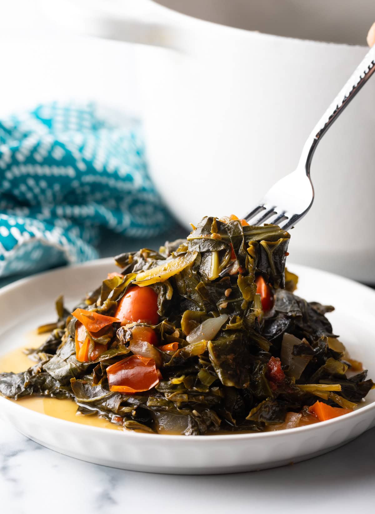 Fork digs into a plate filled with Callaloo greens. 