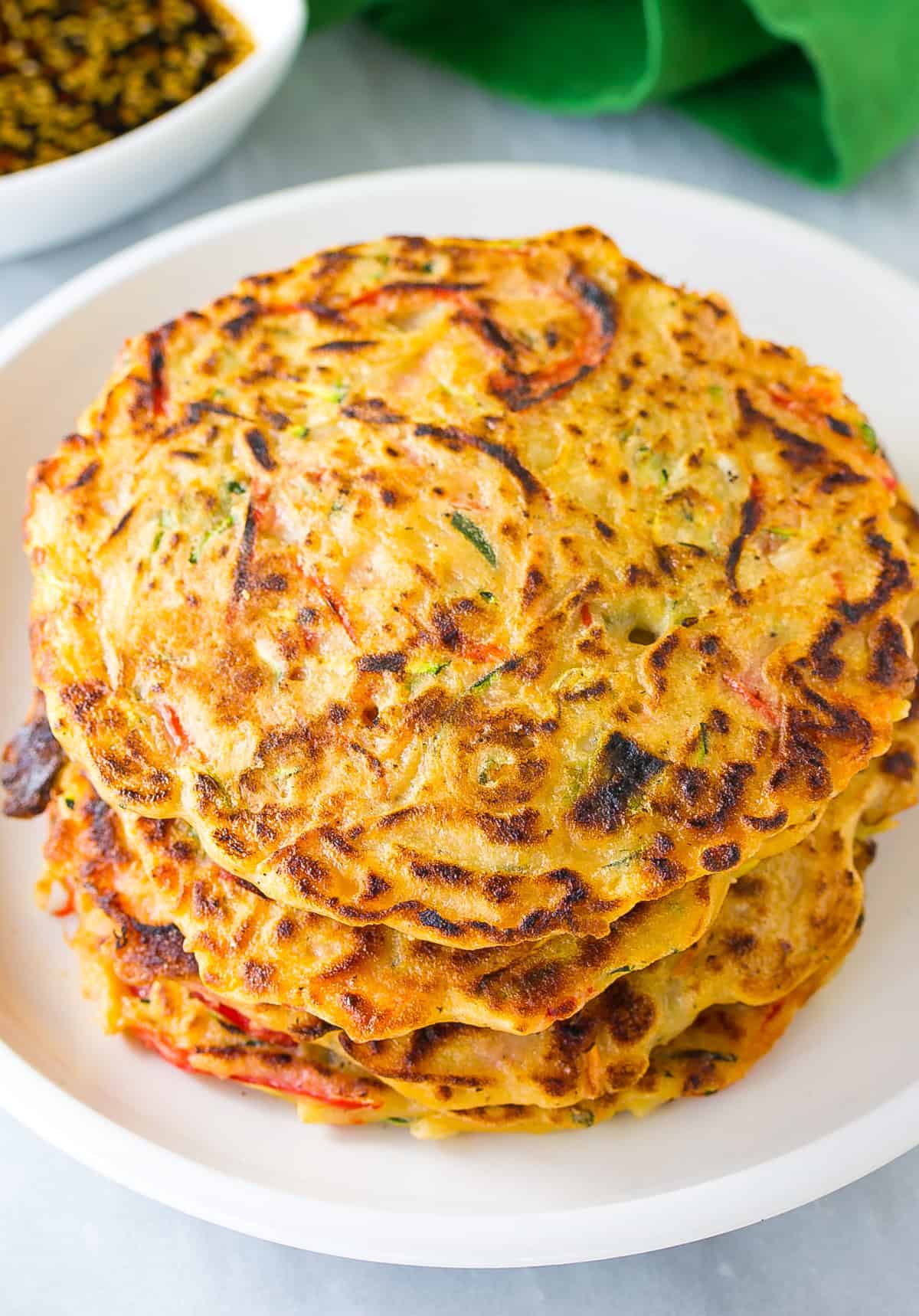 Korean Pancakes #ASpicyPerspective #KoreanPancakes #KoreanPancakeRecipe #Pajun #Pajeon #Korean #Vegetarian Easy korean pancake recipe stacked on white plate
